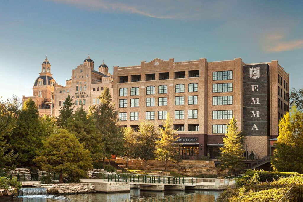 Hotel Emma's brick brewhouse towers at the Pearl, seen across landscaped water on the Museum Reach