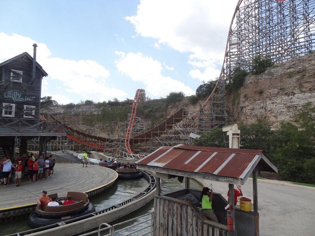 The Iron Rattler roller coaster track climbing beside the limestone quarry wall at Six Flags Fiesta Texas