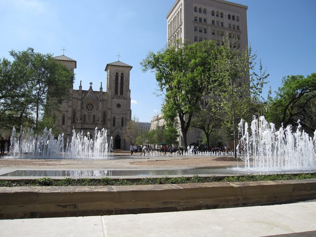 Fountains playing in Main Plaza in front of the twin towers of San Fernando Cathedral on a sunny day