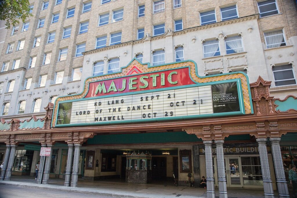 The Majestic Theatre's red and gold marquee and ornate columned entrance on Houston Street beneath the tall Majestic Building