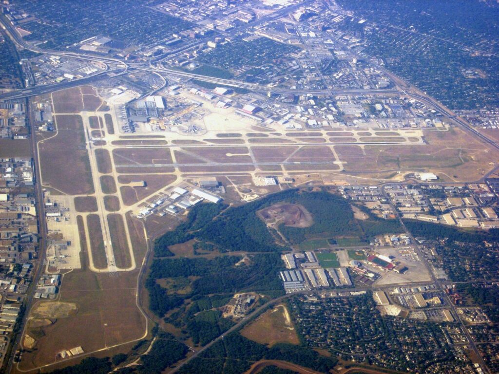 Aerial view of San Antonio International Airport's crossing runways surrounded by north side neighborhoods and freeways
