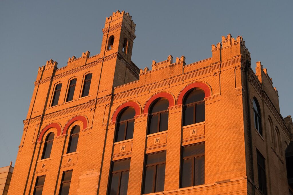 The castle-like red-brick towers of the former Lone Star Brewery, now the San Antonio Museum of Art, glowing in late sun