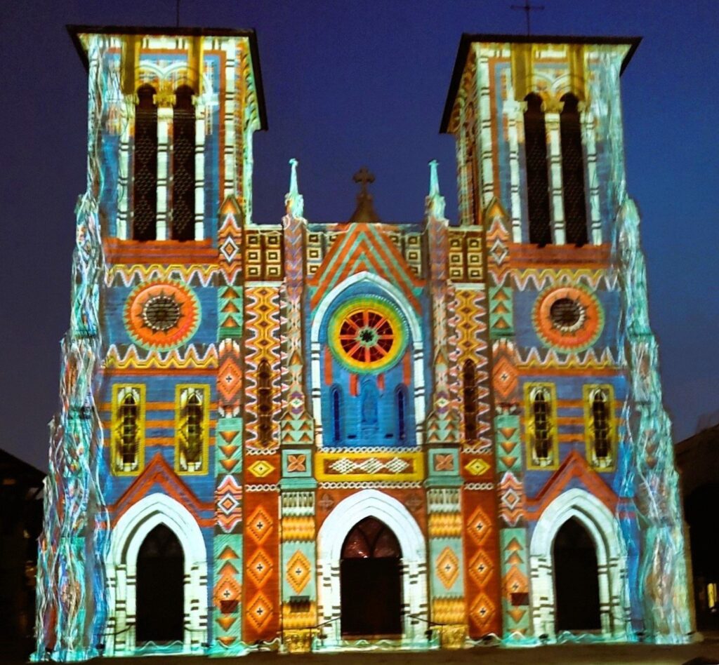 Bright geometric patterns projected across the twin-towered front of San Fernando Cathedral at night
