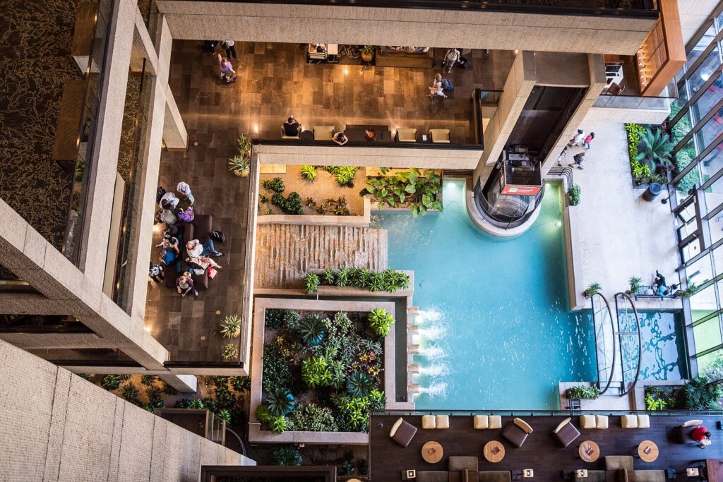 Looking down into the Hyatt Regency San Antonio atrium, with a turquoise water channel, planters and seating areas several floors below