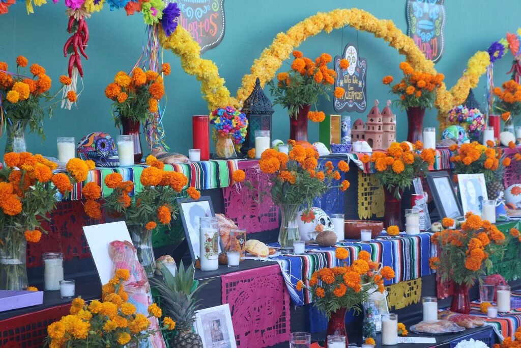 A three-tiered Day of the Dead ofrenda in San Antonio covered in orange marigolds, candles, framed photographs and papel picado